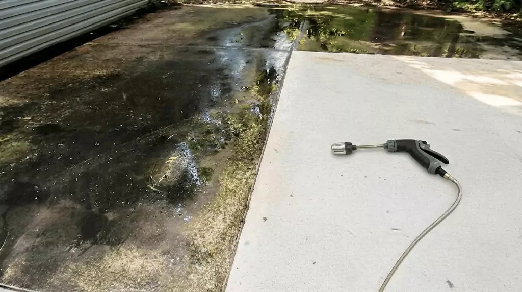 Jetterix LongoMetap test on a narrow concrete strip with years of algae buildup — clear cleaned line through the dirty area